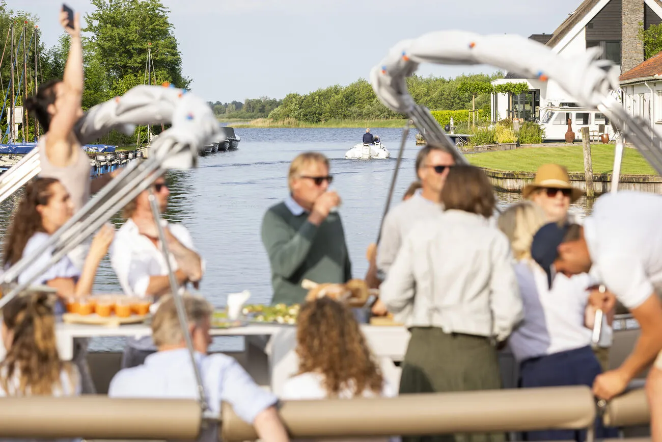Gezelschap proost aan boord bij de jachthaven