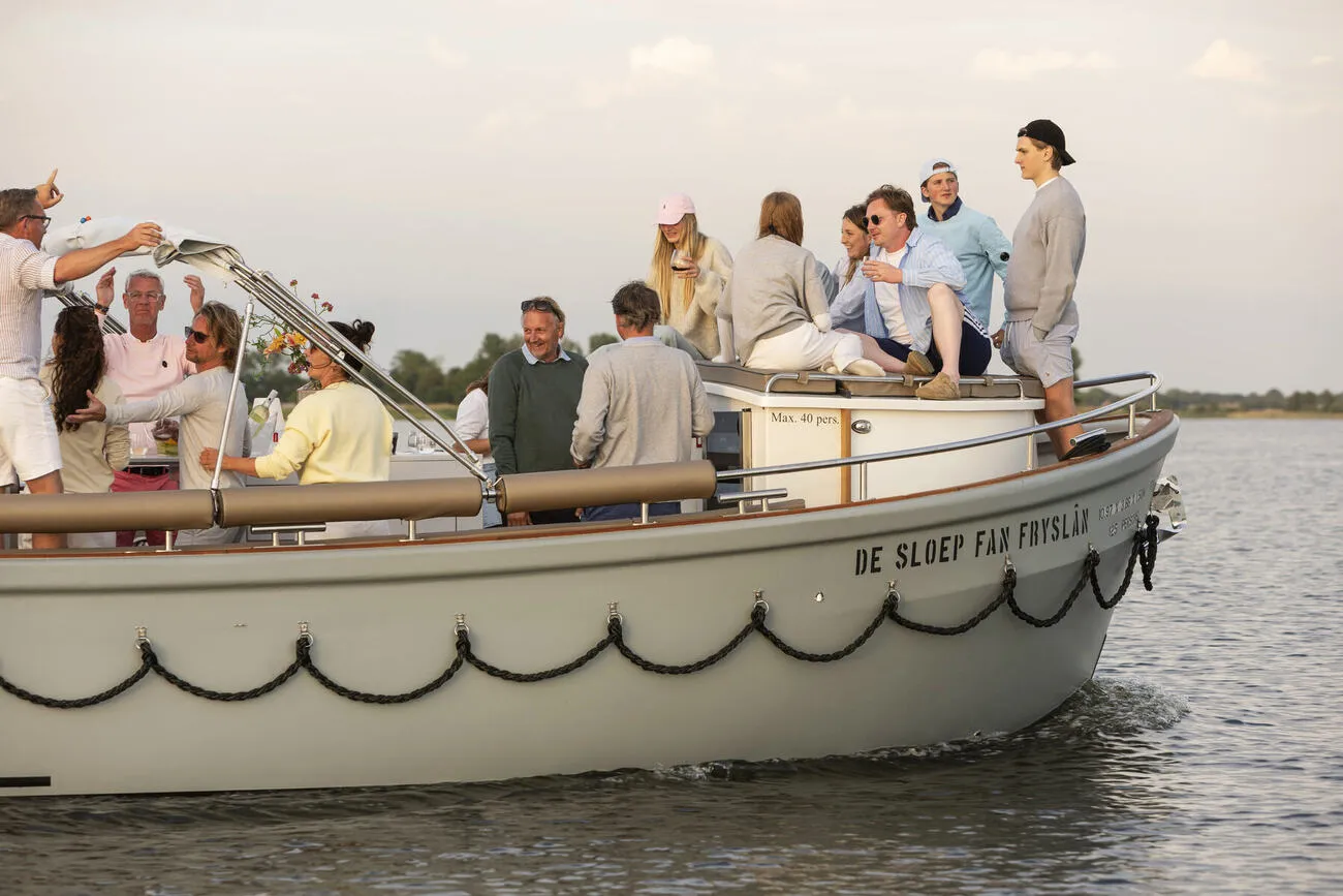 Gezelschap aan boord van De Sloep fan Fryslân op het meer